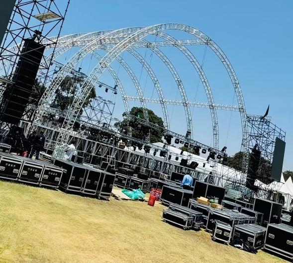 Grande estrutura de treli&ccedil;a de alum&iacute;nio curvada com v&aacute;rios arcos e palco de evento.jpg